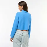 Sweater de punto grueso en color azul, con cuello alto y diseño de manga larga.