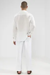 Pantalón de lino blanco con cintura elástica y cordón ajustable. Corte recto y holgado.