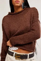 Sweater de punto grueso color beige, de calce amplio y largo corto, con escote redondo, mangas caídas y terminaciones acanaladas en tejido abierto.