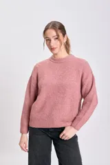 Buzo de punto en color rosa viejo, de cuello redondo, manga larga y diseño holgado con puños y ruedo acanalados.