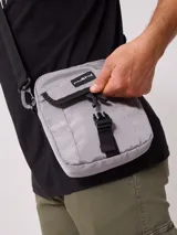 Bandolera negra de nylon con correa ajustable y logo Rusty estampado en blanco.