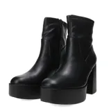 Botas de caña media Miss Carol modelo Placid, confeccionadas en material sintético elastizado color negro. Presentan una plataforma alta y un taco cuadrado robusto, con un diseño minimalista y ajustado al tobillo.