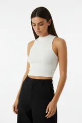 Top de punto acanalado con cuello alto y diseño sin mangas, corte ajustado al cuerpo.