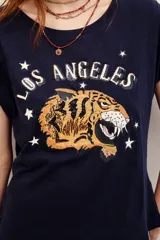Remera blanca de algodón con cuello redondo, mangas cortas con vuelta y estampa frontal de un tigre con la inscripción 'Los Angeles' y estrellas.