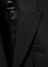 Blazer de corte entallado y diseño recto, con cuello de solapa con muesca, hombros estructurados y manga larga. Cuenta con dos bolsillos de ribete delanteros, detalle de pinzas y abertura posterior.