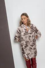 Vestido corto color beige con estampado de paisajes en marrón, cuello mao y mangas largas con puños abotonados.