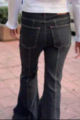 Jean oxford de tiro medio en color negro, con costuras a la vista y corte acampanado en la parte inferior.