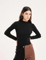 Polera negra de tejido de punto acanalado, con cuello alto y mangas largas.