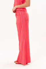 Pantalón de tiro medio y pierna amplia, con diseño a rayas en tonos rojos y rosados, bolsillos y pasacintos.