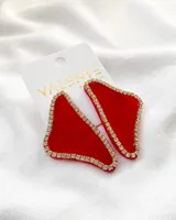 Par de aros colgantes con forma geométrica irregular, color rojo con borde dorado con strass.