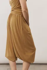 Pantalón holgado negro tipo bombacho, con cintura elástica y puños fruncidos en los tobillos.