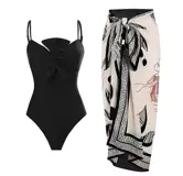 Traje de baño entero negro con breteles finos, detalle de frunce con moño en el busto y espalda baja. Incluye pareo estampado en tonos neutros.