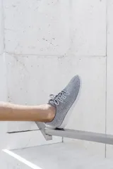 Zapatilla de diseño minimalista confeccionada en lana merino, con cordones al tono y suela de EVA. Presenta un estilo atemporal y versátil, ideal para uso diario.