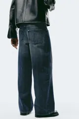 Jean de cinco bolsillos en denim de algodón rígido, color azul oscuro. Modelo de corte holgado de cadera a bajo con pierna amplia y tiro caído. Cintura estándar y cierre.