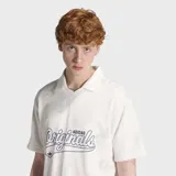 Remera polo Adidas de manga corta, color blanco con cuello tipo polo y estampado frontal con el texto "Originals" en estilo gráfico deportivo.
