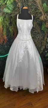 Vestido largo de fiesta color marfil, con corset bordado en hilo y strass, falda amplia de organza y escote cuadrado.