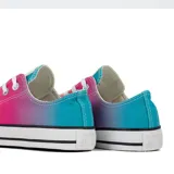 Championes Converse Chuck Taylor All Star de caña baja, con capellada de lona con degradé de colores: celeste, fucsia, naranja y amarillo. Suela y puntera de goma blanca, con dos líneas negras en la entresuela.