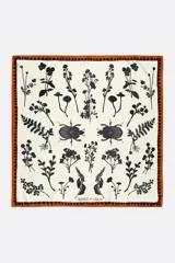 Pañuelo cuadrado de poliéster reciclado con estampado botánico y de escarabajos en color negro sobre fondo crema, con borde decorativo en tono naranja.