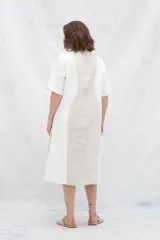 Vestido tipo kaftán en lino color blanco y beige, con tajo en el escote y cortes curvos en la delantera en dos tonos.
