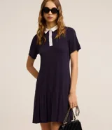 Vestido corto azul marino de manga corta, con cuello polo y solapa de botones en contraste de color blanco. Presenta diseño acanalado en tejido de viscosa y falda con sutil vuelo.