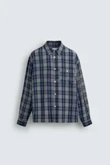 Camisa de corte relajado confeccionada en tejido fluido con mezcla de viscosa y acetato. Presenta un diseño a cuadros, cuello solapa, manga larga con puños abotonados, bolsillo plastrón en el pecho y cierre frontal con botones.