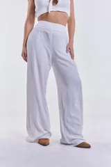 Pantalón blanco de pierna ancha y tiro alto, con pretina elástica fruncida.