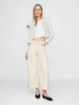 Jean de corte recto y tiro alto, con diseño tipo utility que incluye bolsillos frontales de parche y ruedo con dobladillo ancho. Presenta costuras a la vista en tono contrastante.