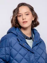 Campera capitoneada color ladrillo con capucha, cierre frontal con botones a presión y cremallera, bolsillos laterales y puños elastizados.