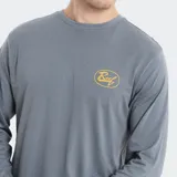 Remera de manga larga color gris, con cuello redondo y pequeño logo de la marca Reef estampado en color amarillo sobre el pecho.
