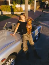 Top negro sin mangas con escote off-shoulder, detalle fruncido y calce ajustado.