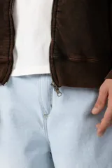 Campera oversize con capucha y cierre frontal, confeccionada en tela con acabado acid wash que le otorga un aspecto desgastado. Presenta costuras curvas decorativas en el frente y la espalda, puños y ruedo acanalados, y un calce relajado.