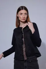 Blusa de estilo romántico con frente de lino y espalda y mangas de algodón con elastano. Presenta un diseño con mini volados en la pechera, cuello redondo y cierre frontal con botones.