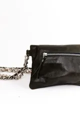 Bandolera de cuero negra con diseño en zigzag de tachas plateadas y asa de cadena metálica.