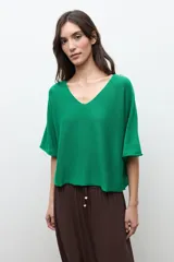 Sweater oversized de punto color verde, con escote en V y mangas cortas holgadas.