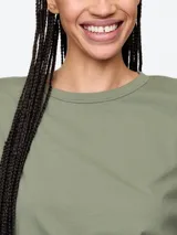 Remera de manga larga color salmón, con cuello redondo y corte holgado.