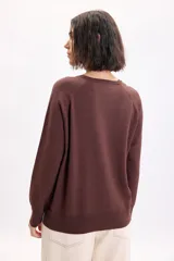 Sweater de punto fino con hilo lurex en color marrón, cuello redondo y mangas largas con hombros caídos.