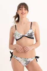 Bombacha de bikini blanca con estampado de hojas tropicales en tonos verdes y negros. Tiene tiras laterales negras para ajustar.