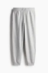 Pantalón deportivo de felpa liviana con interior cepillado, cintura elástica con cordón de ajuste, bolsillos laterales y puños acanalados en los tobillos.