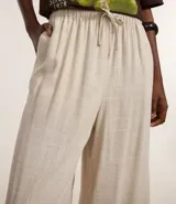 Pantalón de corte holgado y fluido, color negro, con cintura elástica y lazo ajustable. Confeccionado en una mezcla de viscosa y lino.