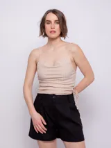 Top sin mangas color beige, con escote en V drapeado y tirantes finos. Presenta frunces laterales ajustables con cordón, creando un efecto cut out.