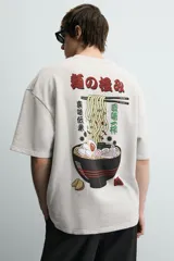 Sudadera gris de corte relaxed fit, cuello redondo y manga corta. Presenta un estampado en el pecho con la frase "Tokyo Kitchen" en un óvalo rojo con palillos.