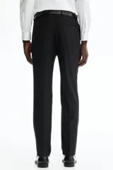 Pantalón de traje de corte ajustado, con cierre y corchete oculto, bolsillos laterales y bolsillos traseros ribeteados. Presenta raya marcada en las piernas y diseño con margen de costura en la pretina.