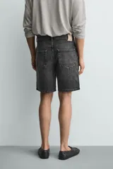 Bermuda de jean con corte regular fit, confeccionada en denim de algodón con elasticidad. Presenta diseño de cinco bolsillos, efecto lavado y cierre frontal con cremallera y botón.