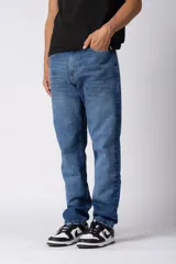 Jean de corte recto y calce cómodo, confeccionado en denim azul con lavado clásico. Presenta diseño de cinco bolsillos, cierre frontal con botón y costuras reforzadas.
