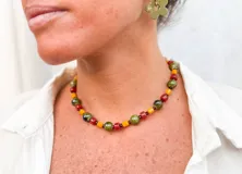 Collar corto de cuentas de colores verde oliva, rojo ladrillo y amarillo mostaza.
