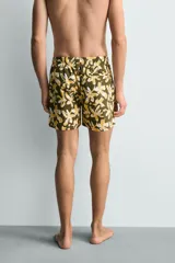 Bañador de hombre con estampado floral en tonos amarillo y blanco sobre fondo verde oliva. Presenta cintura elástica ajustable con cordón, bolsillos frontales y forro interior.