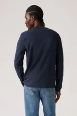 Remera de manga larga color azul marino, con cuello redondo y un pequeño parche rojo con el logo de Levi's en el pecho.