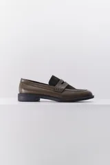 Mocasín de cuero color verde oliva con detalles en gamuza verde oscuro, punta redonda y taco bajo.