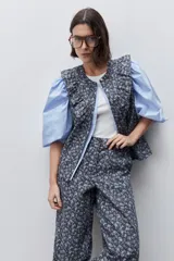 Pantalón de tiro alto con silueta amplia y piernas rectas, confeccionado en algodón con estampado floral. Cuenta con cierre frontal de botón y cremallera, y bolsillos laterales funcionales.