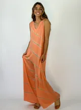 Mono largo de corte holgado con escote en V y sin mangas. Presenta un diseño estampado con líneas diagonales en tonos naranja y beige.